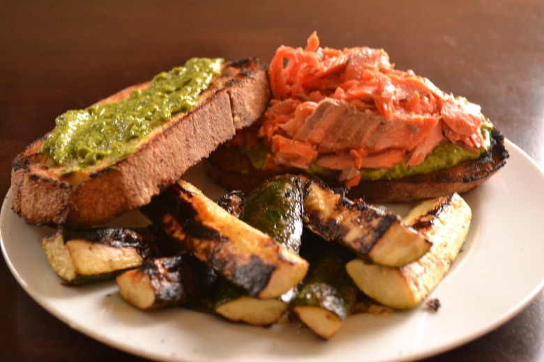 Flaked salmon sandwich with avocado pesto some grilled lemony zucchini